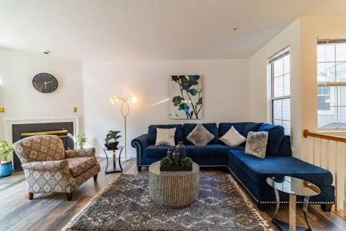 a living room with a blue couch and a chair at Refreshing and Restful Stay in Montgomery Village