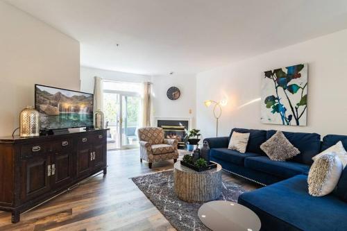 a living room with a blue couch and a tv at Refreshing and Restful Stay in Montgomery Village