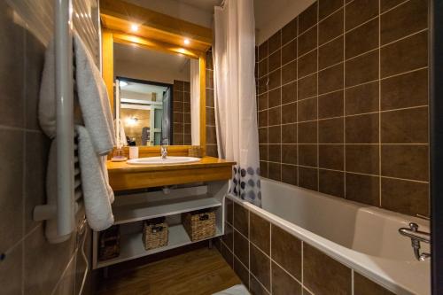 une salle de bain avec un lavabo, une baignoire et un miroir dans l'établissement Apartment for 4 - 6 people in Albiez-Montrond, à Albiez-Montrond