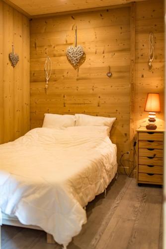 une chambre avec un lit blanc et un mur en bois dans l'établissement Apartment for 4 - 6 people in Albiez-Montrond, à Albiez-Montrond