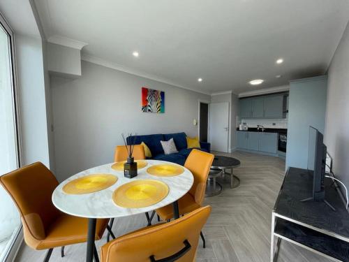 a dining room and living room with a table and chairs at Exquisite Sea View Apartment in Salthill, Galway in Galway