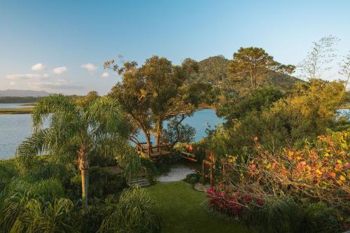 an aerial view of a garden with trees and water at Santi Sabai Ibira - Um Refúgio às Margens da Lagoa in Imbituba