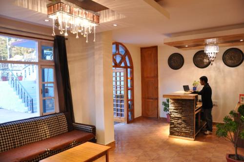 a man standing at a counter in a restaurant at Hotel Ekant in Chail