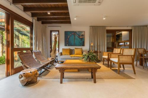 a living room with a couch and chairs at Santi Sabai Ibira - Um Refúgio às Margens da Lagoa in Imbituba