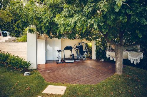 a wooden deck with a tree and exercise equipment at Villa STAMIRA in Ancona