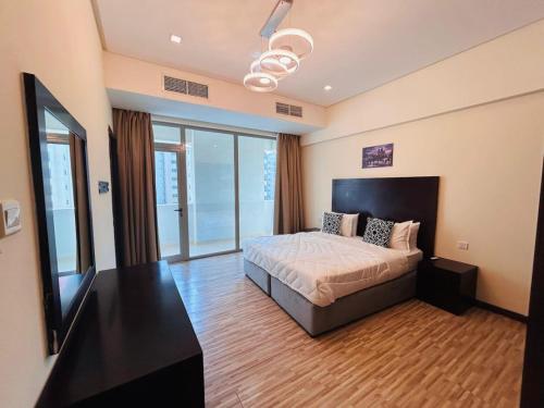 a bedroom with a bed and a flat screen tv at Aspire Tower-Two Bedroom Palm Stay in Manama