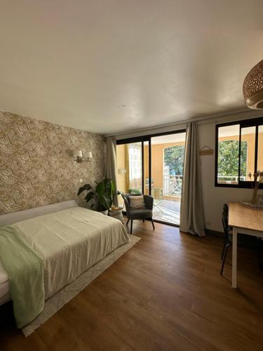 une chambre avec un lit, une chaise et des fenêtres dans l'établissement Villa Francia Cannes, à Cannes