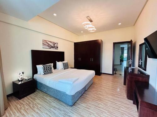 a bedroom with a bed and a flat screen tv at Aspire TowerTwo Bedroom Pilot Paradise in Manama