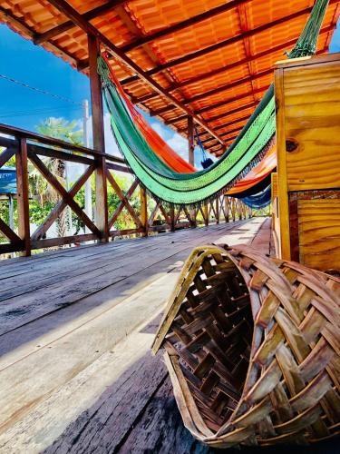 a hammock on a deck with a hammock at Pousada Salinas de Atins in Atins