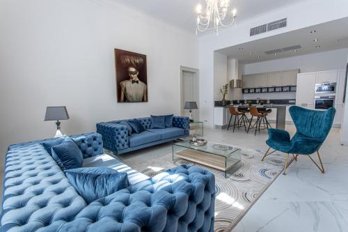 a living room with blue couches and a kitchen at Kozmo Residences Budapest in Budapest