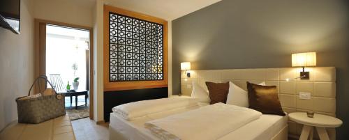 a bedroom with a white bed and a window at Post Hotel - Tradition & Lifestyle Adults Only in San Candido
