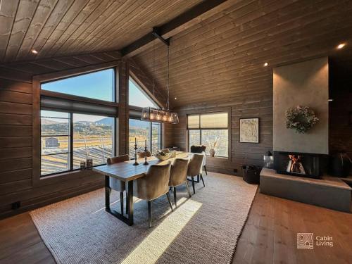 a dining room with a table and chairs at Modern cabin at Høgevarde panoramic view, fireplace and EV station in Granheim