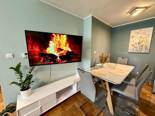 - une salle à manger avec une table et une cheminée au mur dans l'établissement Belgrade Apartment 1, à Zvezdara