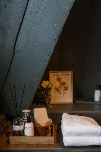 a bathroom with a shelf with towels and a picture at Molen den Bonk in Lexmond