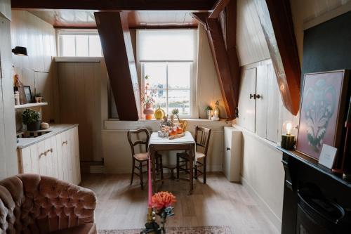 a kitchen with a table with chairs and a window at Molen den Bonk in Lexmond