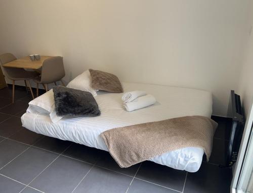 - un lit avec des serviettes et une table dans une chambre dans l'établissement Jolie Studio, à Gare des Brotteaux