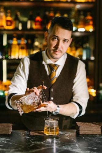 a man in a vest and tie holding a drink at Crowne Plaza Belgrade by IHG in Belgrade