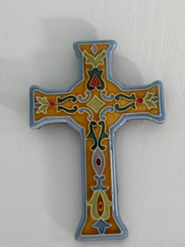 a cross is hanging on a white wall at Casa vacanze Vista Castello in Oria
