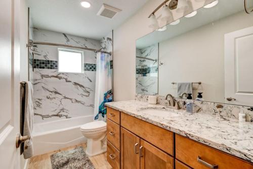 a bathroom with a sink and a tub and a toilet at Cape Key Updated Beach Bungalow in Port Orange