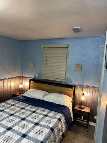 a bedroom with a bed and a blue wall at 3 PM Checkout! in Moorhead