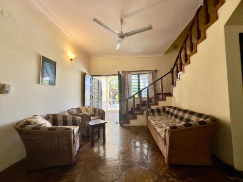 a living room with two couches and a staircase at Banana Villas in Watamu