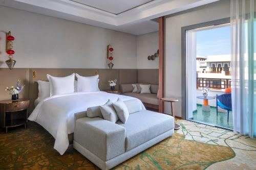 a bedroom with a bed and a chair and a window at Four Seasons Hotel Rabat at Kasr Al Bahr in Rabat