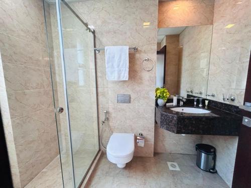 a bathroom with a shower and a toilet and a sink at Aspire Tower-Two Bedroom Urban Haven Juffair in Manama