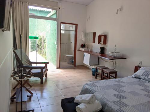 a bedroom with a bed and a kitchen and a bathroom at Green Lodge Eco Life Hotel in Florianópolis