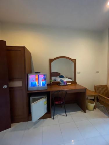 a room with a desk with a mirror and a television at Suwanna Hotel krabi town in Krabi