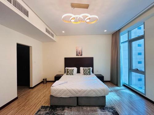 a bedroom with a bed and a chandelier at Aspire Tower-One Bedroom Sunny Solo Stay in Manama