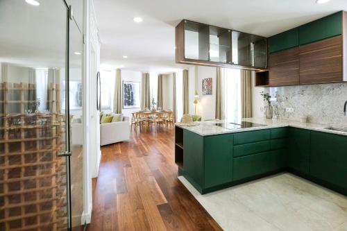a kitchen with green cabinets and a living room at Green Essence Duplex in Faro by Misha's Place in Faro