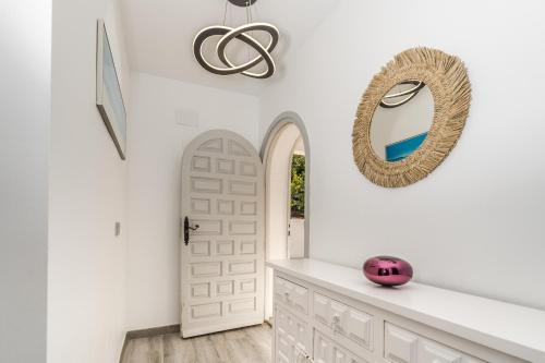 einen Flur mit einer weißen Tür und einem Spiegel in der Unterkunft Beautiful Casa au Lilas Rosa, Benissa Costa in Benissa