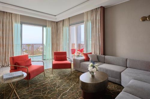 a living room with a couch and red chairs at Four Seasons Hotel Rabat at Kasr Al Bahr in Rabat