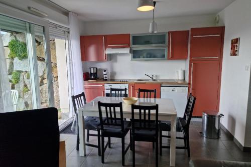 une cuisine avec des armoires rouges et une table et des chaises dans l'établissement Appartement avec vue sur le lac de Gérardmer, proche des pistes de ski, à Gérardmer