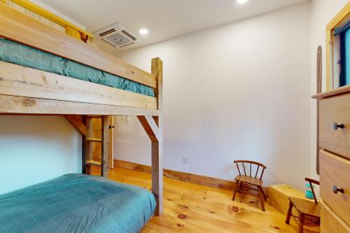 a bedroom with a bunk bed and a chair at The Hollow in Plymouth