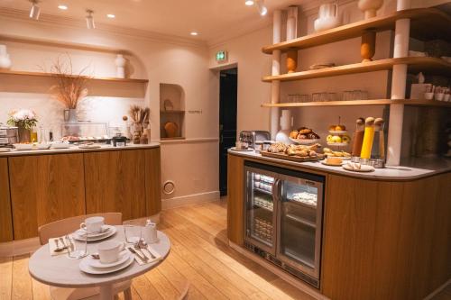 - une cuisine avec une table et un four avec de la nourriture dans l'établissement Hôtel Oratio, à Paris