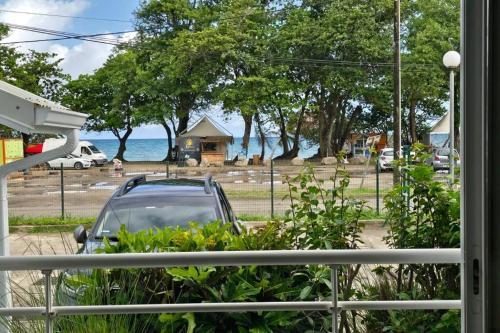 a car parked outside a window with a view of the ocean at Appartement face à la mer 2 chambres in Le Diamant