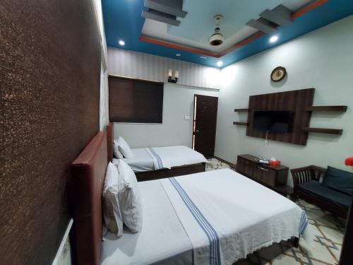 a hotel room with two beds and a tv at Diplomat Inn Hotel in Karachi