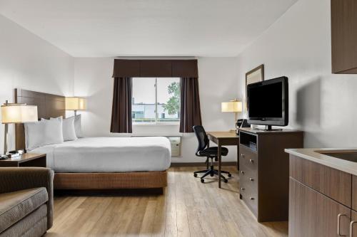 a hotel room with a bed and a television at Days Inn by Wyndham Steinbach in Steinbach