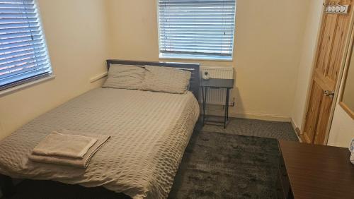 a small bedroom with a bed and a table at Convenient En-suite Double in Oxford