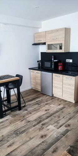 Il comprend une cuisine dotée de parquet, d'une table et d'un comptoir. dans l'établissement La Pierre 2 studio entier, à Tartas