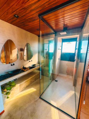 a glass shower in a bathroom with a wooden ceiling at Vila Cangalha in Camocim