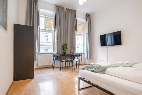 维也纳Amazing 2BR Shared Apt Only 7 Min to Wiener Stadthalle的一间卧室，配有一张床、一张桌子和几把椅子