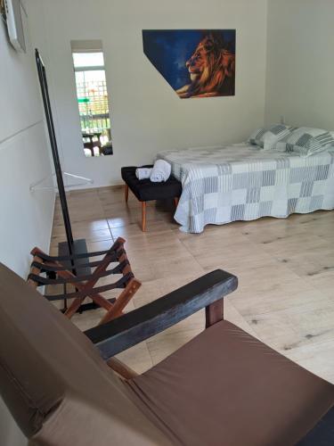 a bedroom with a bed and a chair in a room at Green Lodge Eco Life Hotel in Florianópolis