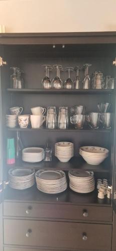 a cabinet filled with plates and bowls and dishes at Haus Alpengruss in Heiterwang