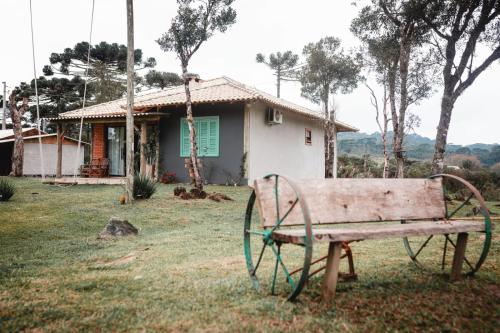 un banco sentado en el césped frente a una casa en Refúgio Altos do Campestre - TURISMO RURAL, en Urubici