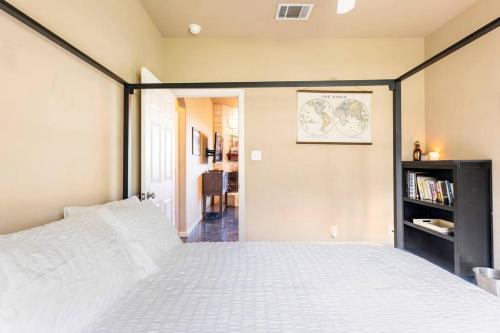 a bedroom with a white bed with a black frame at Casa Vista Chula - Lake Travis - Hot Tub in Buffalo Gap