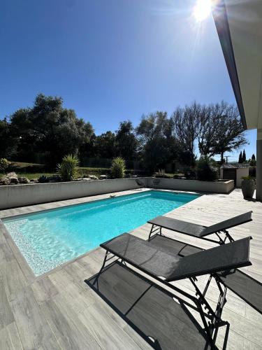 une piscine avec deux chaises et une table dans l'établissement VILLA BENOA, à Oletta