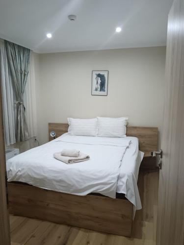 a bed with a white blanket and a towel on it at Dan Kolov in Svilengrad