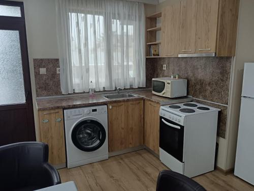 a kitchen with a washing machine and a microwave at Dan Kolov in Svilengrad